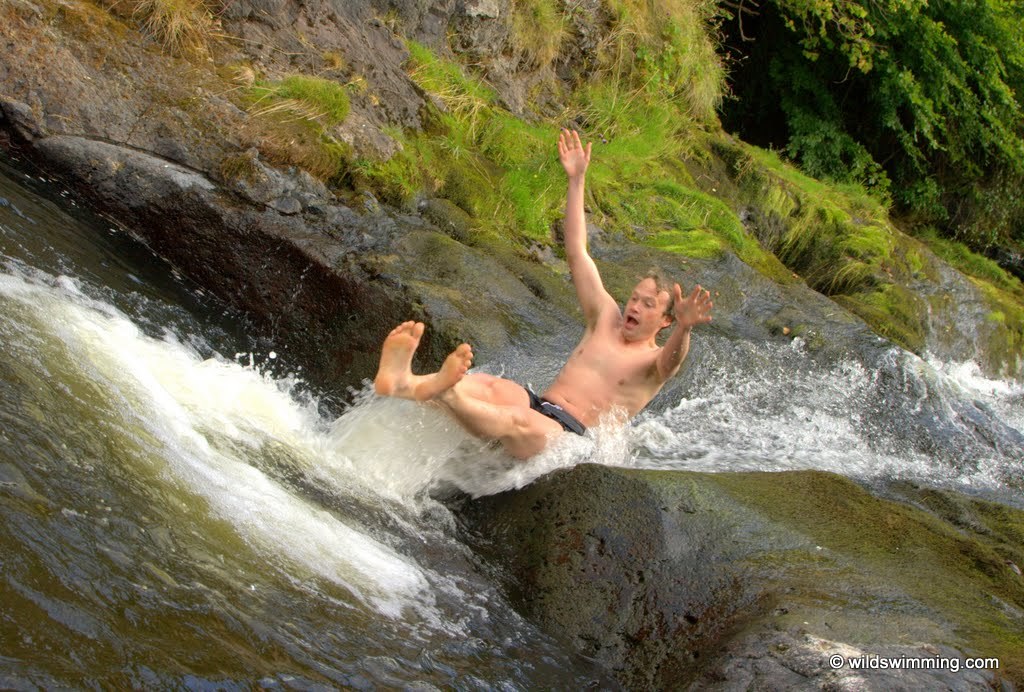 A man taking a slide on a rock in the Sheriff Muir Paradise Pools.