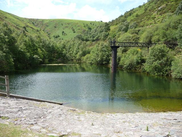 Carding Mill Valley Reservoir scene with lush green hills in the background.